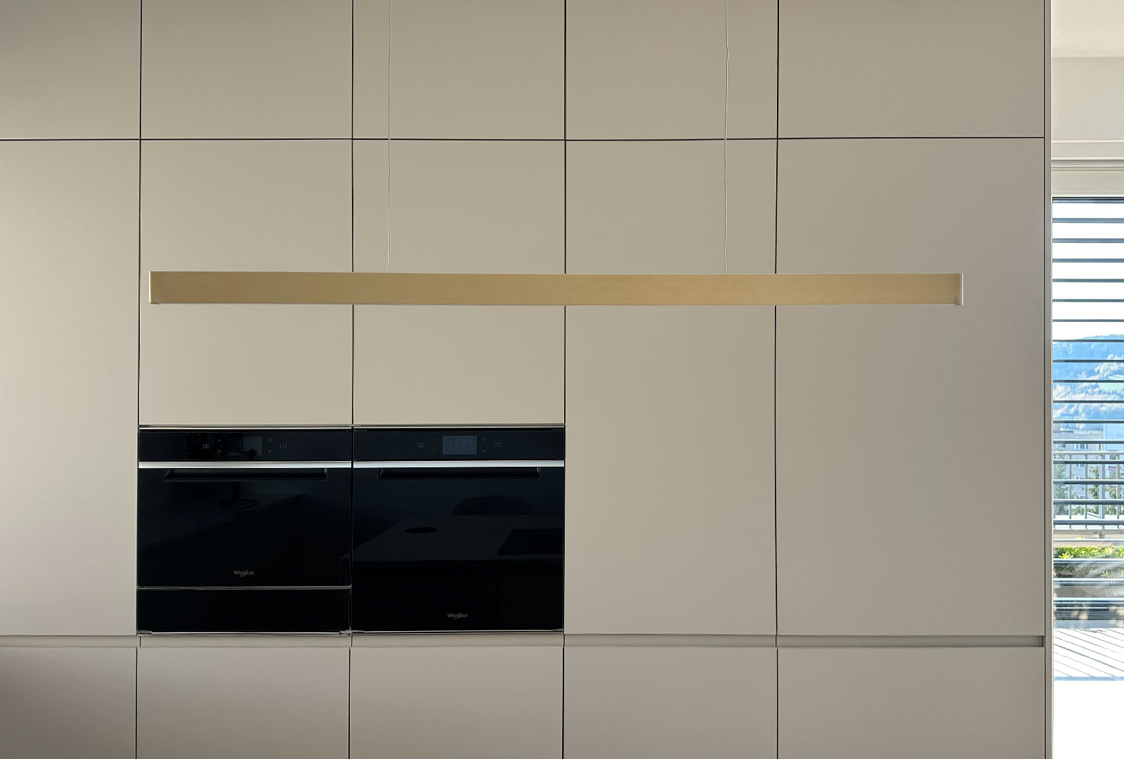 Detail čistých linií matných dvířek a vestavných spotřebičů